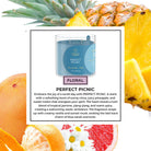 Candle labeled 'Perfect Picnic' with pineapple, orange, and grapefruit in the background